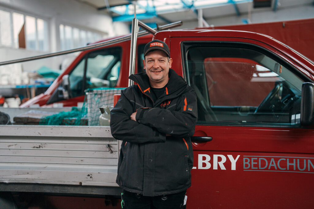 Albry-Mitarbeiter vor dem Firmenfahrzeug in der Werkstatt